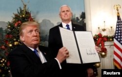 FILE - After signing, U.S. President Donald Trump holds up the proclamation that the United States recognizes Jerusalem as the capital of Israel and will move its embassy there, during an address from the White House in Washington, U.S., Dec. 6, 2017.