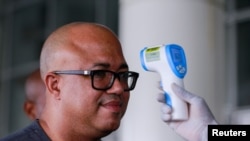 Dr. Chikwe Ihekweazu, the Director General of the Nigeria Centre for Disease Control (NCDC) has his temperature checked during a diplomatic meeting at the Ministry of Foreign Affairs in Abuja, Nigeria on March 12, 2020. 