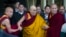 The Dalai Lama, in yellow robe, is helped by attending monks as he leaves after a religious talk at the Tsuglakhang temple in Dharmsala, India, March 14, 2017.