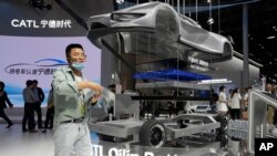 2024 年 4 月 25 日星期四，在北京舉行的 2024 中國國際汽車展上，一名參觀者經過中國電池製造商寧德時代(CATL) 的展位。(美聯社照片)