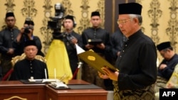 Malaysia's Prime Minister Najib Razak (R) reads his oath declaration in front of Malaysia's King Abdul Halim Mu'adzam Shah (not pictured) as he is sworn in for his second term as prime minister at the National Palace in Kuala Lumpur, May 6, 2013.