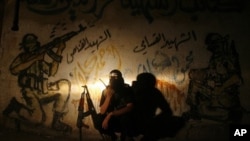 A Palestinian militant member of the Qassam Brigades, Hamas' armed wing, talks on a walkie-talkie at Rafah refugee camp, southern Gaza strip, August 21, 2011