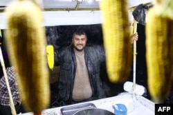 A vendor sells corn from a stall in Syria's northern city of Aleppo, Dec. 10, 2024. In the Syrian capital of Damascus, shops and banks reopened for the first time since Bashar al-Assad's overthrow on Sunday.
