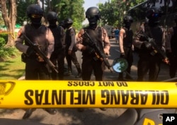 Police officers stand guard near the site where an explosion went off at Santa Maria church in Surabaya, East Java, Indonesia, May 13, 2018.