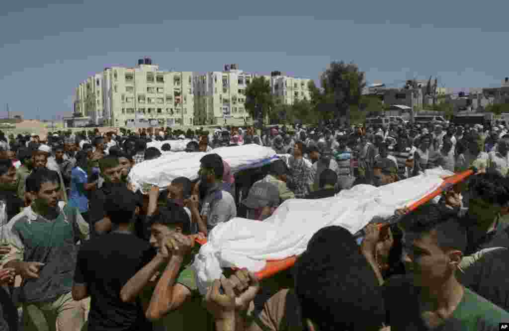 Palestinians carry bodies of 10 members of the Al Astal immediate and extended family that were killed by an Israeli strike on their homes, during their funeral in Khan Younis, southern Gaza Strip, &nbsp;July 30, 2014.&nbsp;