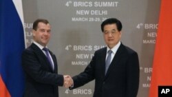 Russia's President Dmitry Medvedev (L) shakes hands with his Chinese counterpart Hu Jintao during their bilateral meeting in New Delhi, March 28, 2012. 
