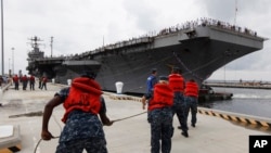 FILE - Navy crews haul in lines as the USS Abraham Lincoln arrives at Naval Station Norfolk in Norfolk, Virgina, Aug. 7, 2012. The U.S. has dispatched the aircraft carrier to the Middle East following “clear indications” that Iran was preparing to possibly attack U.S. forces.