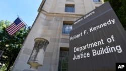 FILE - A sign is seen in front of the United States Justice Department in Washington, Aug. 27, 2015. 
