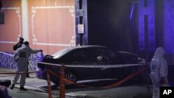 A police officer checks a car that crashed at the gate of the Chinese embassy in Buenos Aires, Argentina, June 22, 2020.