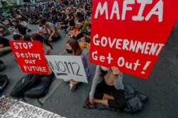Pro-democracy activists display placards during a rally in Bangkok, Thailand, March 24, 2021, ahead of indictment against 13 protest leaders on Thursday for allegations of sedition and defaming the monarchy.