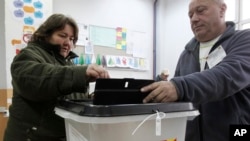 A woman casts her ballot at a polling station in Tearce, northwestern Macedonia, Sunday, Dec. 25, 2016. 