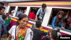 Cambodian workers get off a train as they prepare to migrate back to Cambodia at Aranyaprathet train station in Sa Kaew, June 15, 2014.