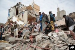 FILE - People inspect the rubble of houses destroyed by Saudi-led airstrikes in Sanaa, Yemen, Aug. 25, 2017. Airstrikes by a Saudi-led coalition targeted Yemen's capital, hitting at least three houses in Sanaa and killing at least 14 civilians, including women and children, residents and eyewitnesses said.