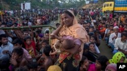 A Rohingya Muslim woman, who crossed over from Myanmar into Bangladesh, waits to receive aid with hundreds of other displaced Rohingyas, near Balukhali refugee camp, Bangladesh, Sept. 25, 2017.
