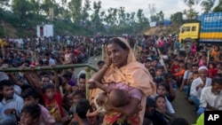 A Rohingya Muslim woman, who crossed over from Myanmar into Bangladesh, wipes her sweat as she waits to receive aid during its distribution near Balukhali refugee camp, Bangladesh, Sept. 25, 2017. 