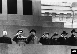 Red China's Mao Tse-Tung (third from left) stands with top Russian leaders to salute from Lenin Mausoleum as parade passes below on Nov. 11,1957 in Red Square at Moscow.