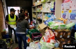 Volunteers from Syria prepare the distribution of hygiene products to migrants at a former police compound outside the Berlin Office of Health and Social Affairs (LaGeSo) in Berlin, Germany, Sept. 7, 2015.