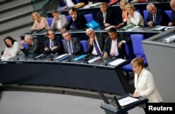 FILE - German Chancellor Angela Merkel (R) delivers a speech at the lower house of parliament Bundestag in Berlin, Germany, June 28, 2016.
