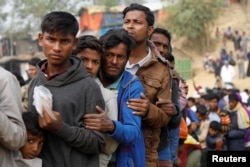 Rohingya refugees line up at a daily essentials distribution point at Balukhali camp, near Cox's Bazar, Bangladesh, Jan. 15, 2018.