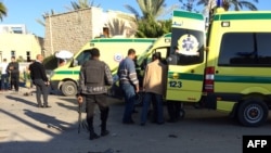 FILE - Emergency personnel and security forces stand next to ambulances outside the Swiss Inn hotel in the Egyptian town of El-Arish, in the Sinai peninsula, following an attack on the hotel Nov. 24, 2015.
