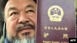 This handout picture released by Chinese dissident artist Ai Weiwei on July 22, 2015 shows Ai Weiwei posing with his passport in Beijing. 