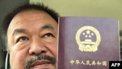 FILE - This handout picture released by Chinese dissident artist Ai Weiwei on July 22, 2015, shows him posing with his passport in Beijing. 