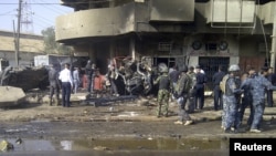 Petugas keamanan menginspeksi lokasi ledakan bom mobil, yang meledak saat berlangsungnya perayaan keagamaan Syiah di Baghdad (13/6). 