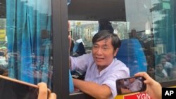 A man looks out from a bus window as people look for their family members and relatives on a bus carrying prisoners who released from Insein Prison, Nov. 17, 2022, in Yangon, Myanmar.