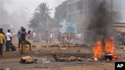 FILE - Anti-government protesters burn tires and place rocks in the streets in Conakry, Guinea, May 3, 2013