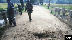 FILE - Myanmar soldiers view the crater from a landmine explosion on a bridge in Maung Nama Taung village, Nov. 12, 2016. UNICEF reported on April 3, 2024, that more than 1,000 people were killed or maimed by landmines in Myanmar in 2023.