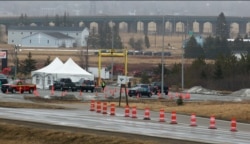 FILE - Nova Scotia border agents are seen at the border checkpoint with New Brunswick as part of the measures against the spread of COVID-19 in Amherst, Nova Scotia, Canada, April 2, 2020.