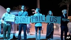 Activists hold signs at the COP27 U.N. Climate Summit, Nov. 19, 2022, in Sharm el-Sheikh, Egypt.