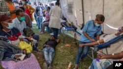A man lies down after giving blood at a blood drive in support of Ethiopia's military at a stadium in the capital, Addis Ababa, Ethiopia, Nov. 12, 2020.