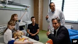 US Secretary of State Antony Blinken meets children talks with Marina, 6, left, from Kherson region ,during a visit to a children hospital in Kyiv, Ukraine, Thursday, Sept. 8, 2022. (Genya Savilov, Pool Photo via AP)