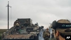 Ukrainian military vehicles move on the road in the freed territory in the Kharkiv region, Ukraine, Monday, Sept. 12, 2022.
