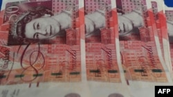 FILE - British pound notes are displayed at a money changer in Kuala Lumpur, Jan. 16, 2017. The face of the new King Charles III will soon begin to appear on British coins and banknotes.