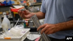 A biologist holds a tool for wastewater collection at a lab in Queens College, New York City, Aug. 25, 2022. Since a polio case was identified in July in New York state's Rockland County, the disease has been detected in New York City sewage, suggesting the virus is spreading.