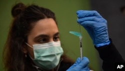 FILE - A medical staff member prepares a Pfizer vaccine during a COVID-19 vaccination campaign in Pamplona, northern Spain, on March 16, 2021. 