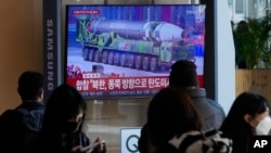 A TV screen shows a file image of a North Korean missile in a military parade during a news program at the Seoul Railway Station in Seoul, South Korea, Nov. 18, 2022. South Korea said a missile North Korea launched Friday morning was likely an intercontinental ballistic missile.