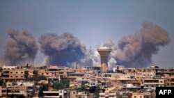 Smoke rises above rebel-held areas of the city of Daraa during reported airstrikes by Syrian regime forces, July 5, 2018.