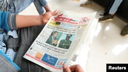 FILE - A man reads a newspaper with the pictures of Amhara state President Ambachew Mekonnen, killed in Bahir Dar, and of Army Chief of Staff Seare Mekonnen, who was shot by his bodyguard, on a street in Addis Ababa, Ethiopia, June 24, 2019.