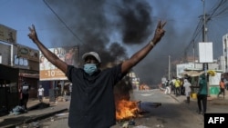 An opposition supporter reacts in front of a burning barricade during demonstrations called by the opposition parties in Dakar on Feb. 4, 2024.