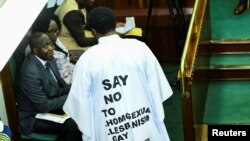 FILE - Member of Parliament from Bubulo contituency John Musira, dressed in an anti-gay gown, attends the debate of the Anti-Homosexuality Act inside the chambers at the Parliament buildings in Kampala, Uganda, March 21, 2023. 