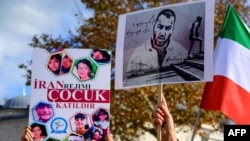 FILE - People hold placards bearing portraits of Iranian rapper Toomaj Salehi, right, who was arrested in Iran, and portraits of children who were killed during protests in Iran, during a rally in support of Iranians in Istanbul, Turkey, Nov. 26, 2022.