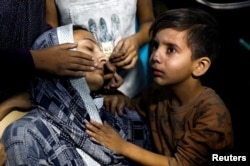 FILE - A Palestinian child cries next to his mother after they were rushed into Nasser hospital, following an Israeli strike, in Khan Younis in the southern Gaza Strip, Nov. 13, 2023.