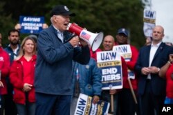 FILE - U.S. President Joe Biden speaks to striking United Auto Workers on the picket line outside the Willow Run Redistribution Center, UAW Local 174, Sept. 26, 2023, in Van Buren Township, Michigan.