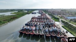 This photo taken on July 26, 2023, shows fishing boats moored at a port in preparation for approaching Typhoon Doksuri in Lianyungang, in China's eastern Jiangsu province. 