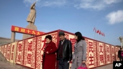 Sejumlah warga berjalan kaki melintasi patung Mao Zedong di Kashgar di bagian barat Wilayah Xinjiang, China, 4 November 2024. (Foto: Ng Han Guan/AP Photo)