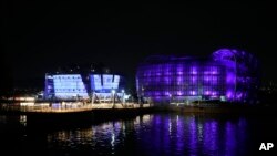 Bangunan terkenal di Pulau Sebitseom di Sungai Han di Seoul, Korea Selatan, terlihat menyala ungu, Senin, 12 Juni 2023, merayakannya ulang tahun ke-10 tahun band K-pop BTS, yang popularitas globalnya menjadi sumber kebanggaan nasional. (AP/Ahn Young-joon)