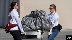 Recovery team members carry a capsule containing NASA's first asteroid samples to a temporary clean room at Dugway Proving Ground in Utah on Sunday, Sept. 24, 2023. (AP Photo/Rick Bowmer, Pool)
